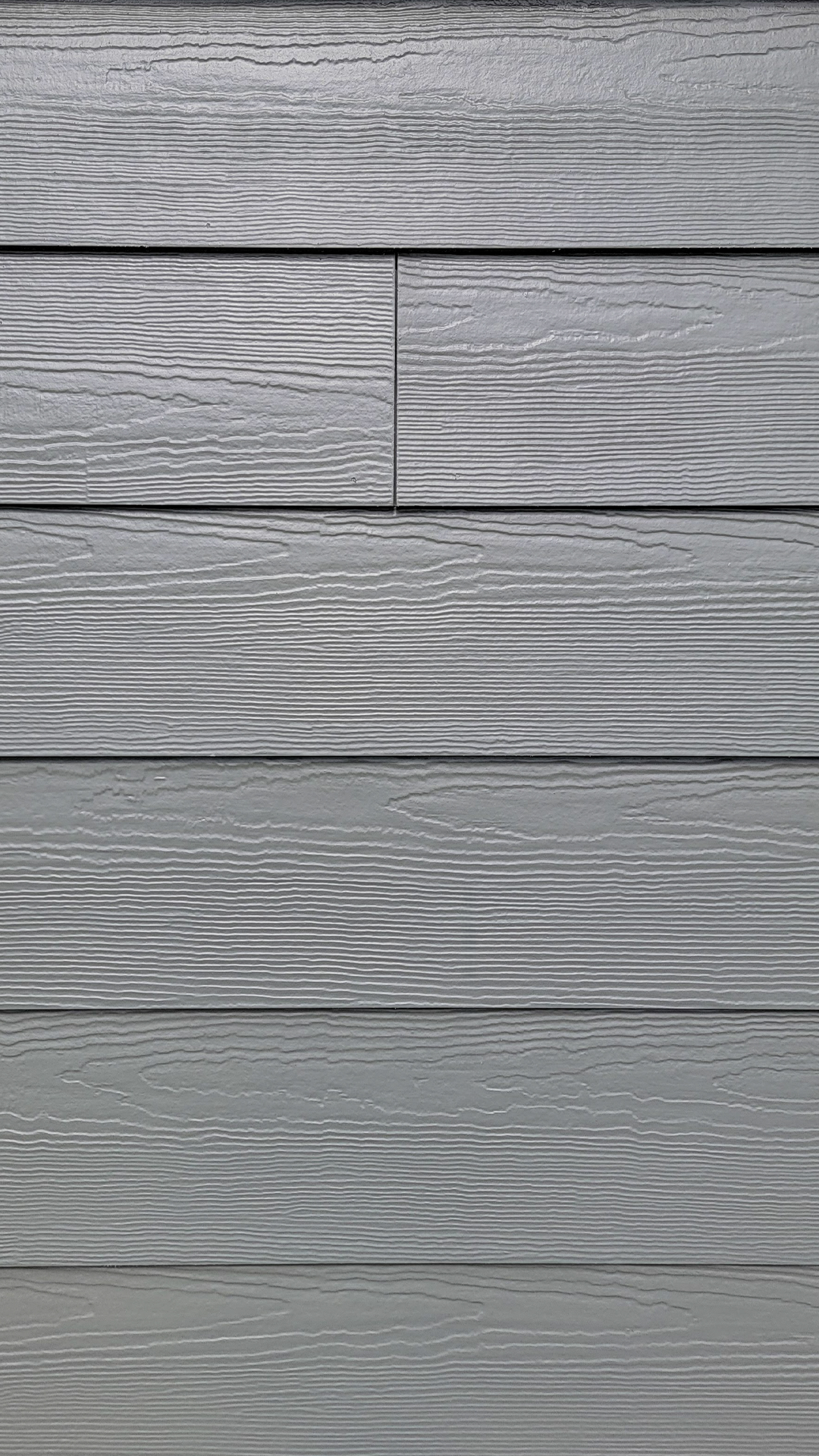 Close-up product photography showing the color, configuration and texture of James Hardie® Building Products Fiber Cement Hardie® Plank Lap Siding in Select Cedarmill. After commercial waterproofing, siding, window & soffit installation by StraightLine Exteriors in Beaverton, Oregon 97005. © StraightLine Exteriors 