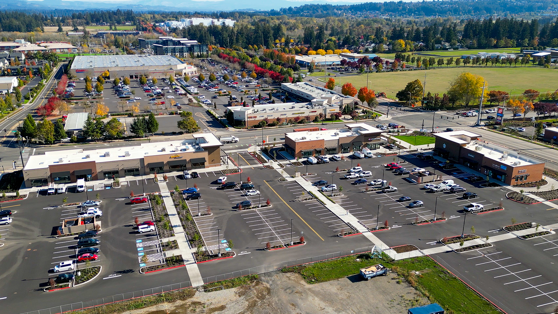 Mid-day aerial photo showing the size, location and scope of the Lacamas Square commercial storefront property development after professional siding & soffit installation by StraightLine Exteriors in Camas, Washington 98607. 