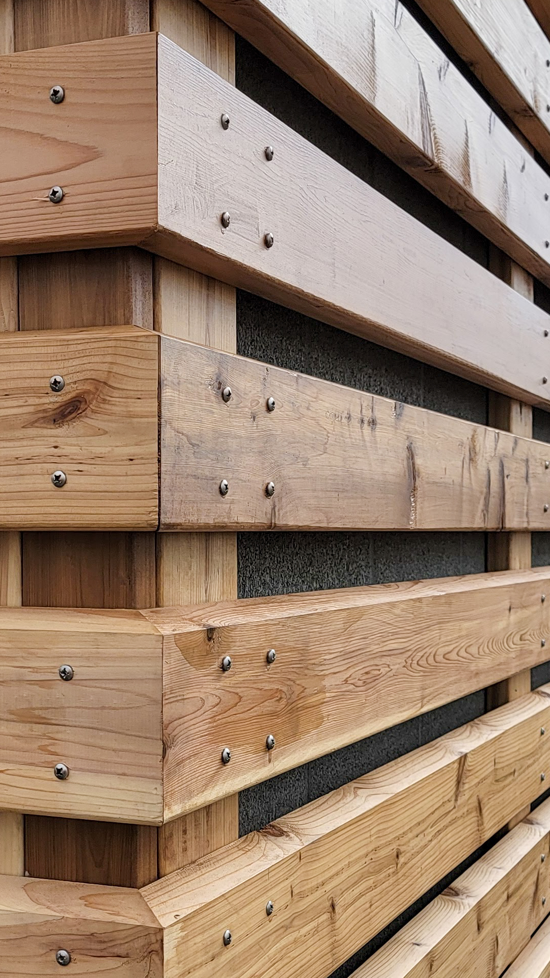 Close-up, angled product photography showing the color, configuration and texture of Stain Grade 2x6 Western Red Cedar in Tight Knot. After commercial waterproofing, siding, window & soffit installation by StraightLine Exteriors in Beaverton, Oregon 97005. © StraightLine Exteriors 