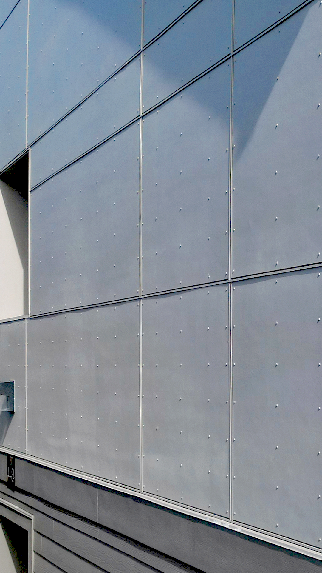 James Hardie® product photo showing the color, texture and scale of Hardie® Architectural Collection Panels in Smooth (Panel & Channel) with Tamlyn® Architectural Trim & Channel. Photo taken at Wingate Square Apartments after commercial siding, soffit & window installation by StraightLine Exteriors in Vancouver, Washington 98662.