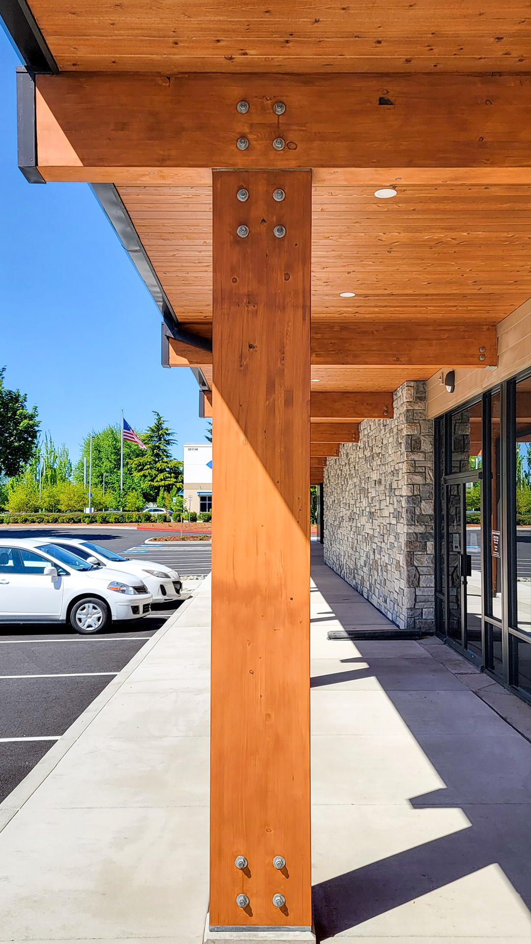 Stained cedar Post & Beam product photo of Cascade Furniture & Mattress after commercial siding, soffit, post & beam installation by StraightLine Exteriors. 