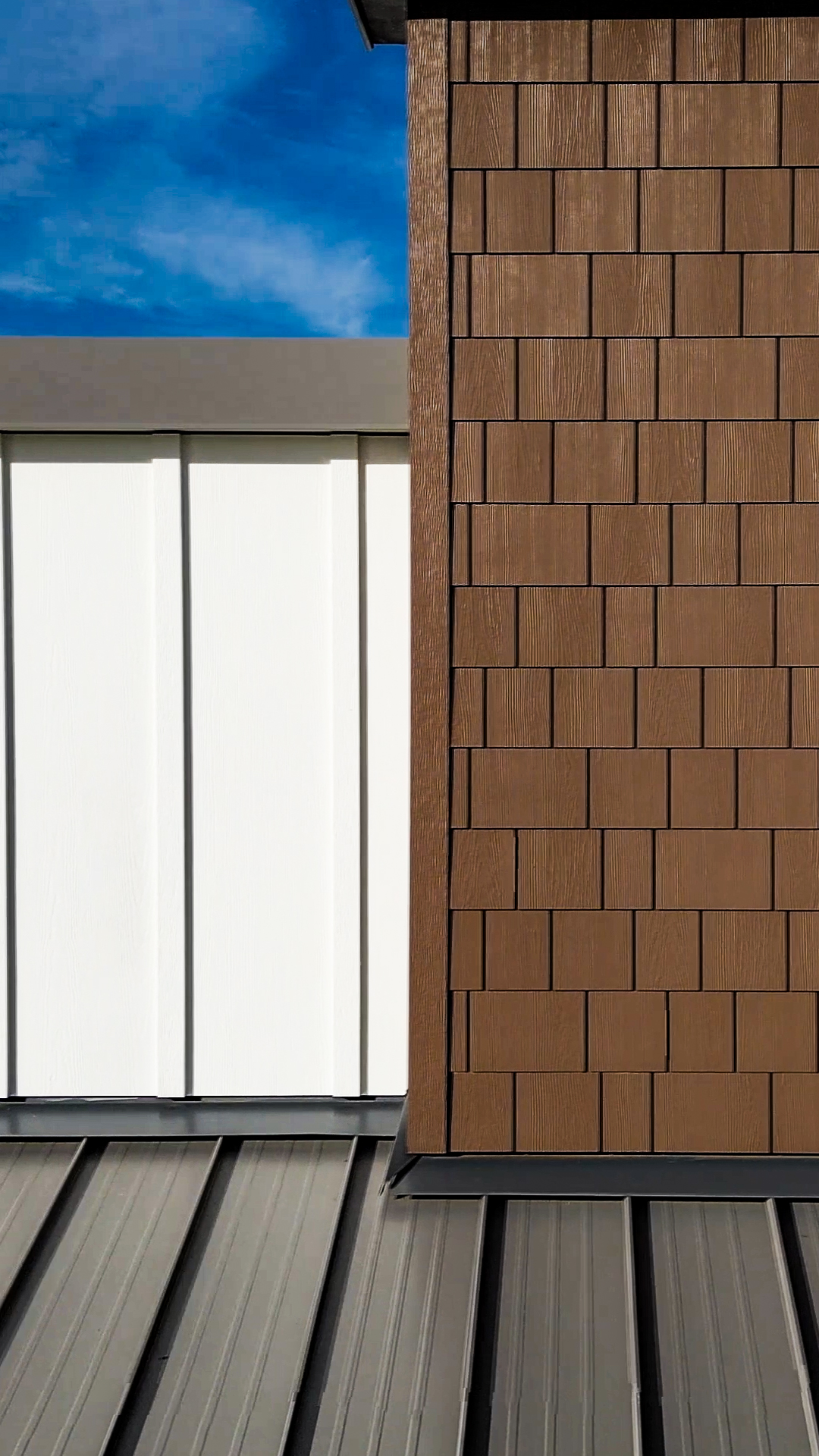 Mid-day fiber cement siding product photo showing the mix of Batten Board & Straight Edge Shingle siding products & exterior design after commercial siding installation by StraightLine Exteriors at Pioneer Village in Ridgefield, Washington 98642.