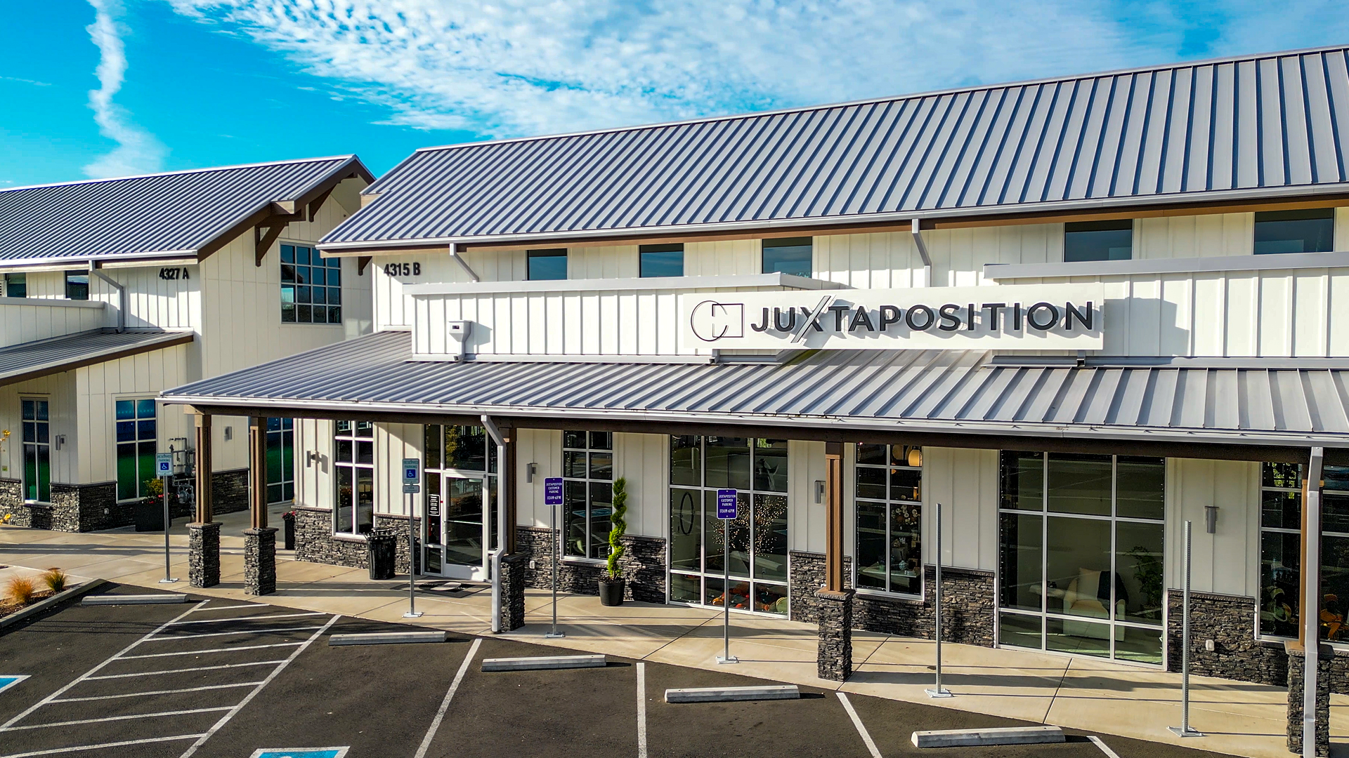 Mid-day photo showing the exterior design of Buildings 5 after commercial siding installation by StraightLine Exteriors at Pioneer Village in Ridgefield, Washington 98642. Products include James Hardie® Fiber Cement : Hardie Panel Vertical Siding (Board & Batten) and Hardie Soffit Panels.
