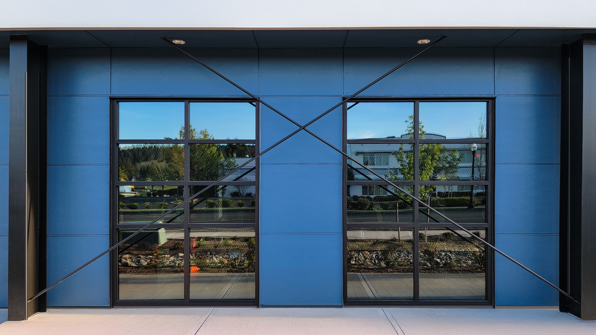 Mid day ground level photograph showing the new Northwest Line Joint Apprenticeship Training Facility (JATC) exterior design and office & classroom exterior elevation. Installed products include James Hardie fiber cement siding Architectural Collection Panels in the texture Fine Sand installed using Tamlyn Architectural Trim & Channel and exposed fasteners. This product was installed by StraightLine Exteriors in Battle Ground, Washington 98604. 