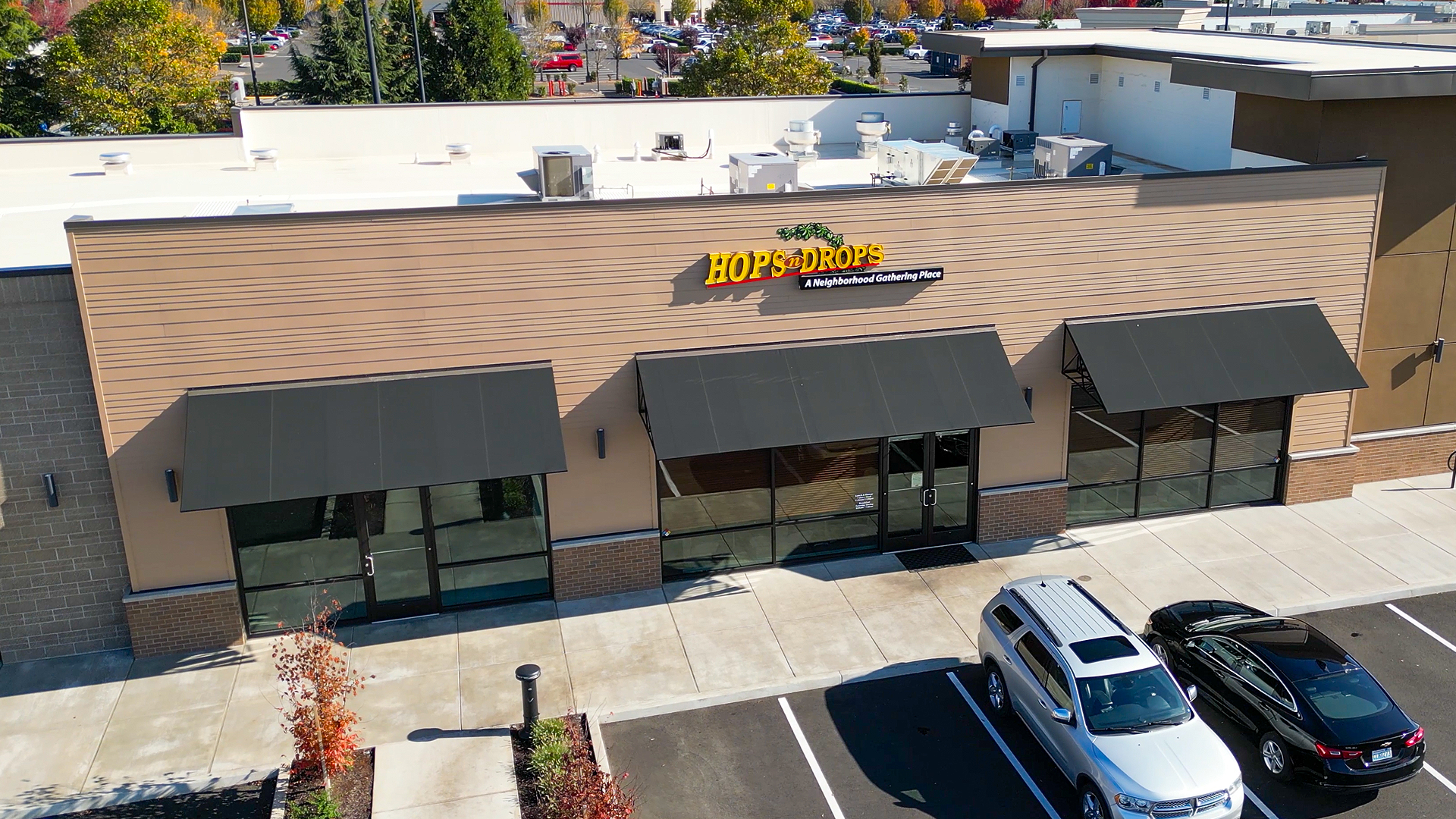 Mid-day aerial photo showing the front corner exterior elevation of Building 6. Installed products include James Hardie® Building Products fiber cement siding of HardiePlank in Select Cedarmill with a staggered reveal of 8in / 4in / 4in / 8 in reveal. Commercial storefront property waterproofing, siding, flashing & soffit installation by StraightLine Exteriors in Camas, Washington 98607. 