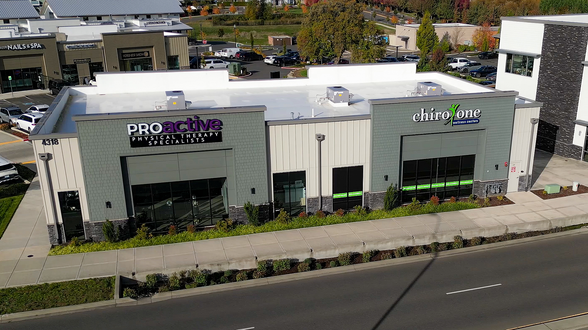 Mid-day aerial photo showing the exterior design of Building 4 after commercial siding installation by StraightLine Exteriors at Pioneer Village in Ridgefield, Washington 98642. Products include James Hardie® Fiber Cement : Hardie Plank Lap Siding, Hardie Panel Vertical Siding (Batten Board), Hardie Architectural Collection Panels and Hardie Soffit Panels.