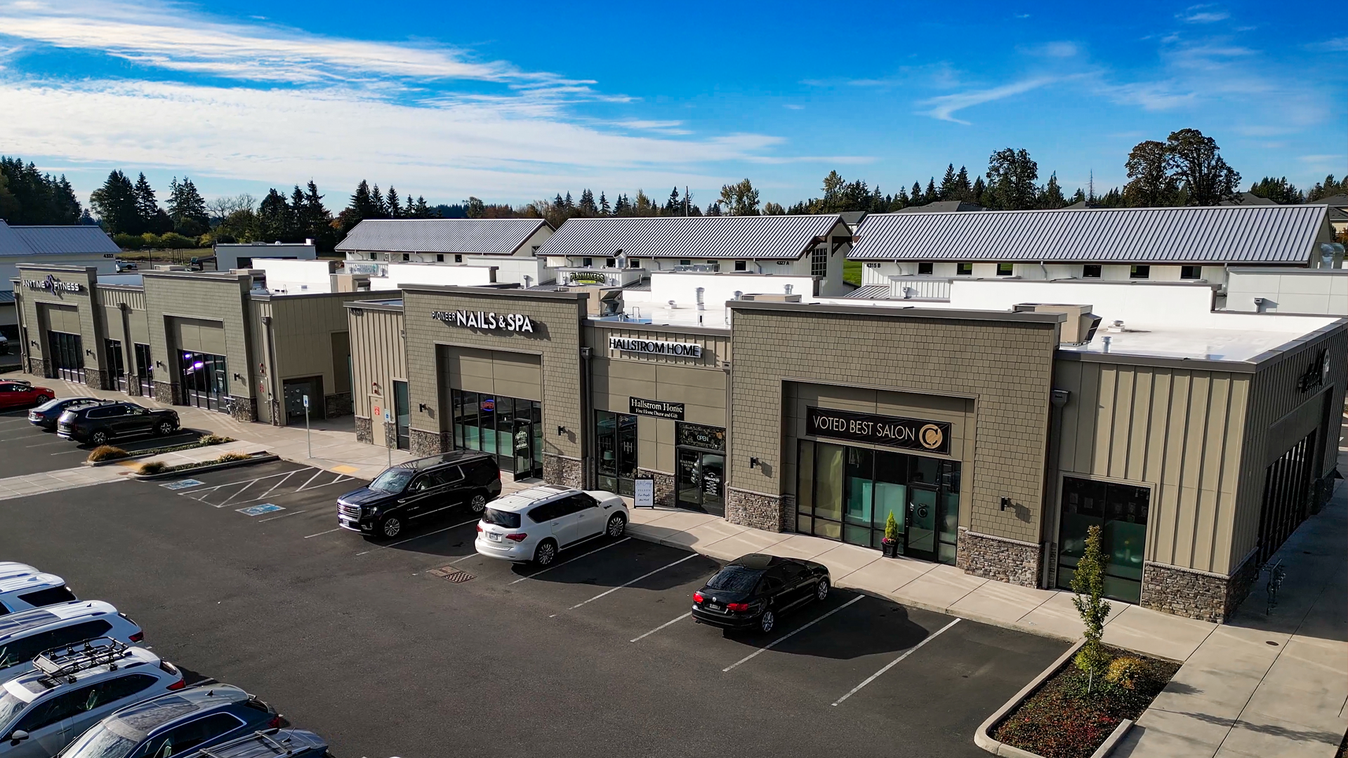 Mid-morning aerial photo showing the western-style elevations of Buildings 9 & 10 after commercial siding installation by StraightLine Exteriors at Pioneer Village in Ridgefield, Washington 98642. 