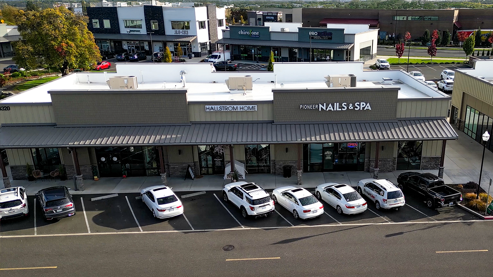 Early morning aerial photo showing the exterior design and western-style storefront of Building 9 after commercial siding installation by StraightLine Exteriors at Pioneer Village in Ridgefield, Washington 98642. 