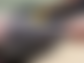 Black and grey forearm tattoo featuring a hunter drawing a bow at a deer in a detailed forest landscape with trees, mountains, and a flowing river.