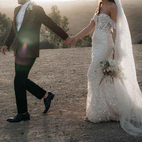 A bride and groom walk through the Agafay desert