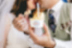 groom holding up a cup of mango gelato