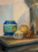 Still-life with a blue jar, golden orb, and candles in low light.