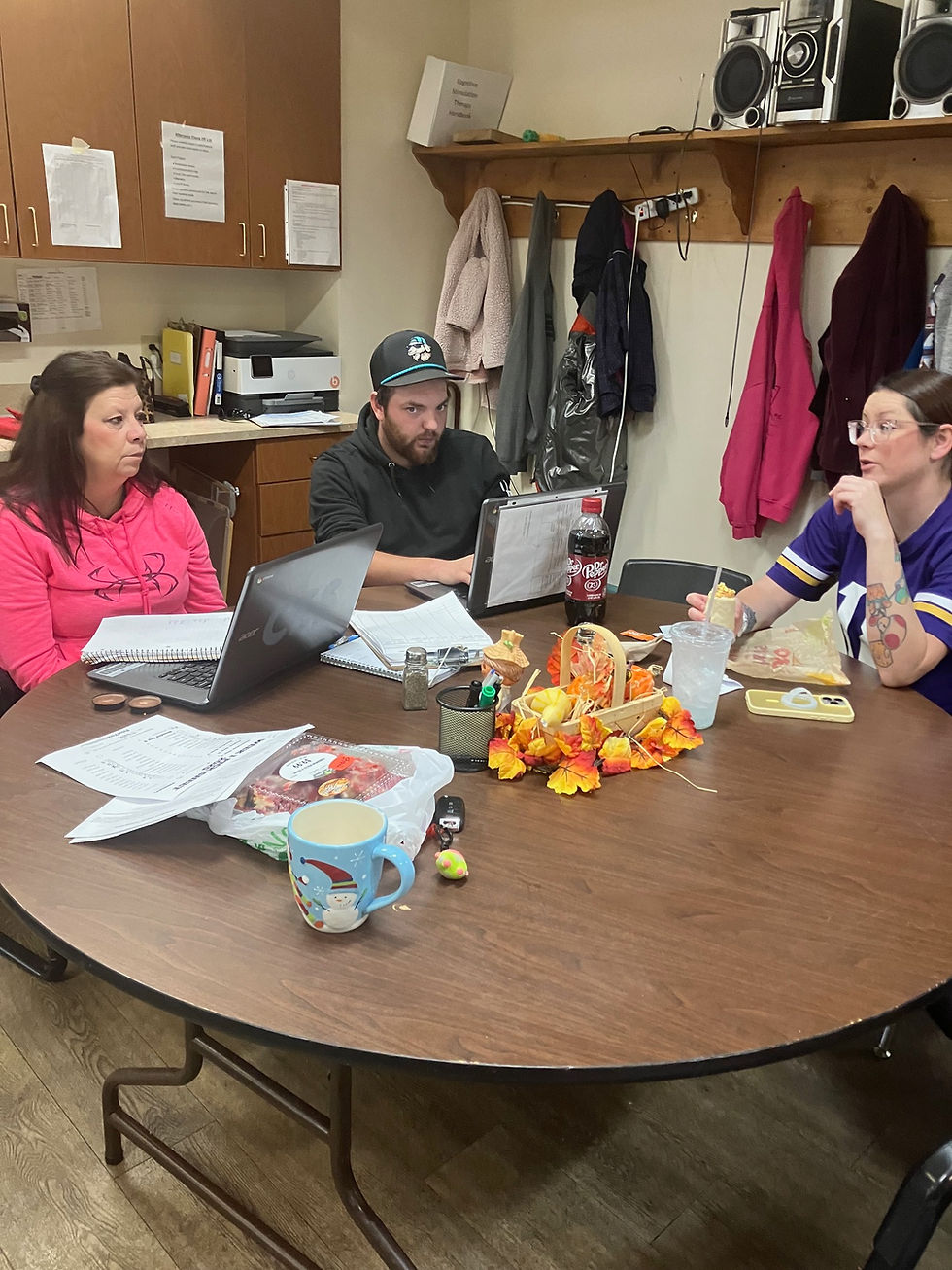 Teresa, Tyler and Ceirra review client charts regularly throughout the day to document each person's progress and what sort of care they received. 