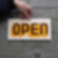 Spelled out signs. Hand painted sign with yellow and maroon lettering that reads "open"