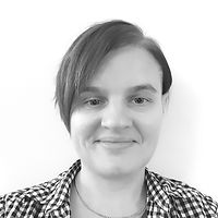 Black and white headshot of Terese – a white woman her forties with short hair, wearing a checkered shirt.