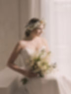 Braut in weiss mit Brautstrauss und blumigem Haarschmuck