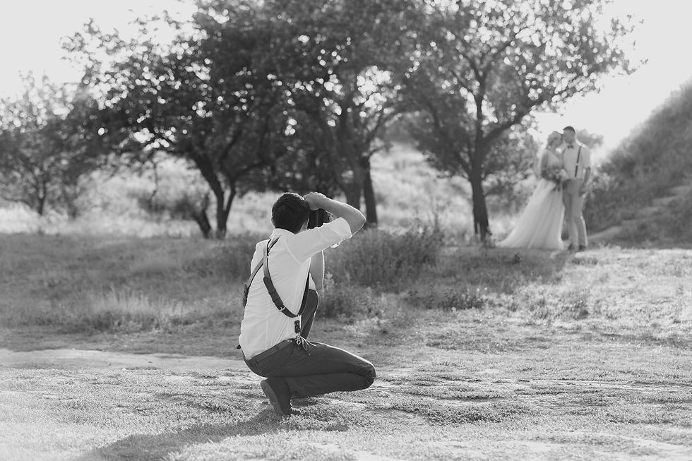 Hochzeitsfotograf fotografiert Brautpaar in der Natur neben Bäumen