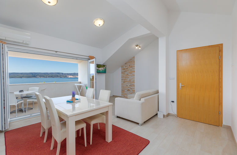 Dining area, sofa and balcony doors with sea view in Apartment 4 at Apartments Bosiljka, Medići.