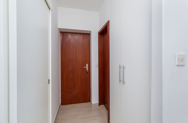 Hallway with integrated wardrobe connected to the bedroom area in the apartment, photographed in natural light.