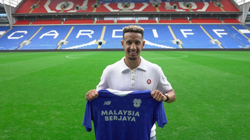 Callum Robinson holding Cardiff City shirt.