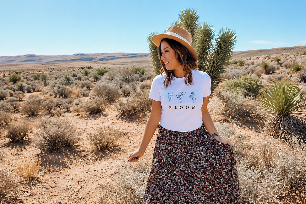 Girl wearing a summer tshirt with flowers and the word BLOOM on it.
