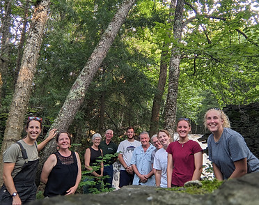 Group photo of the District's Board and Staff members in the forest smiling at the camera.