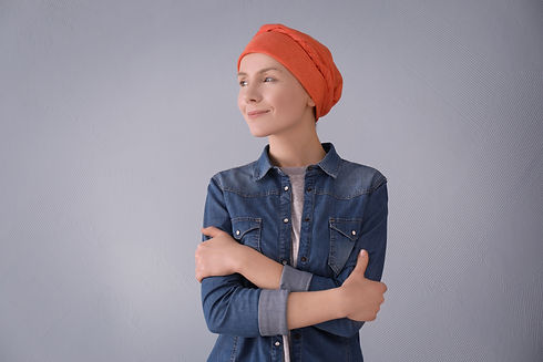 Young woman with cancer in headscarf on grey background.jpg