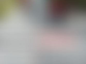 Workers in red outfits install shingles on a rooftop amidst trees. Text overlay: "See how much a roof cost in your area (free estimate)."