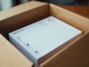 Delivery box opened showing freshly printed postcards ready for distribution