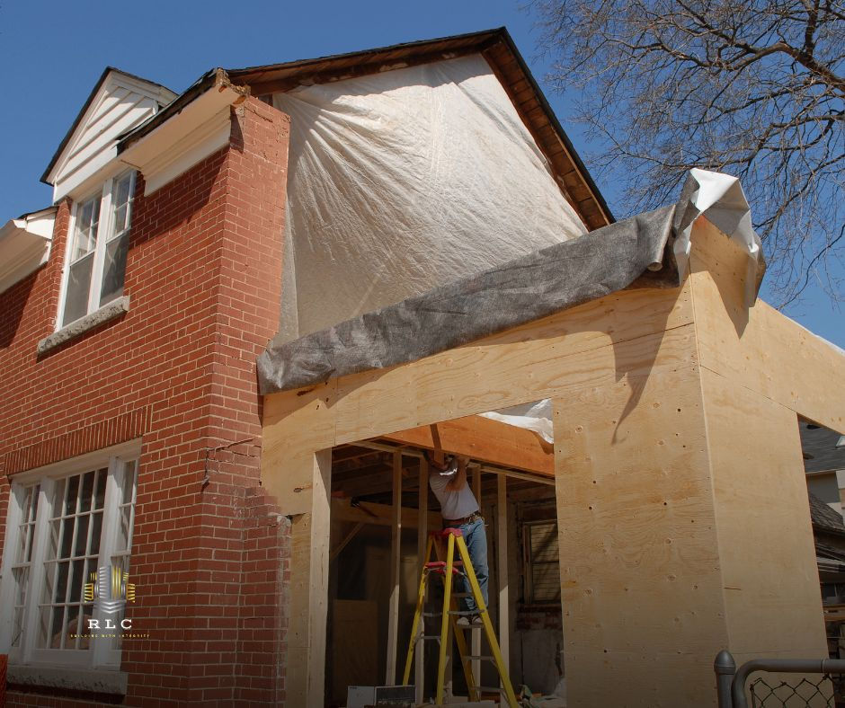 Brick house new addition under construction, worker inside, remodeling contractors Central Florida.