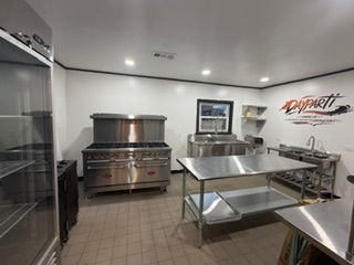 Commercial kitchen with stainless steel stove and prep tables