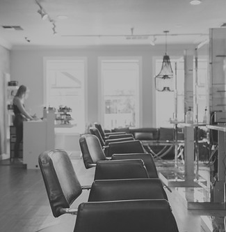 woman in white shirt standing near black leather chairs_edited.jpg