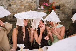 Gasten staan onder paraplu’s tijdens een regenachtig diner in Toscane