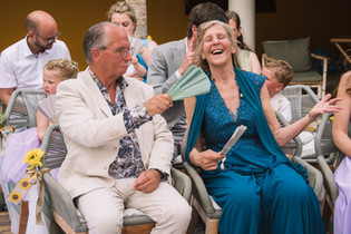 Gasten bij ceremonie met waaiers tijdens een warme bruiloft op Bonaire