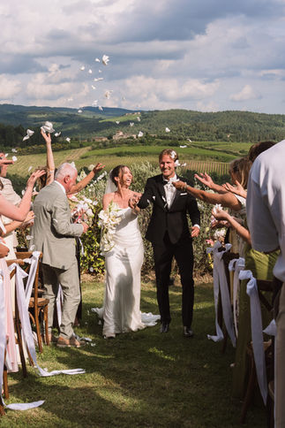 Bruidspaar loopt weg van de ceremonie in Toscane