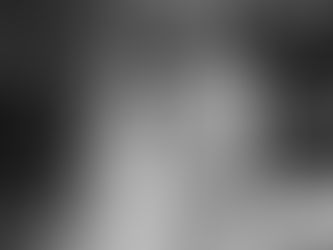 Foto van een bruidspaar die loopt door een tuin in Rotterdam. De bruid kijkt over haar schouder in de camera.