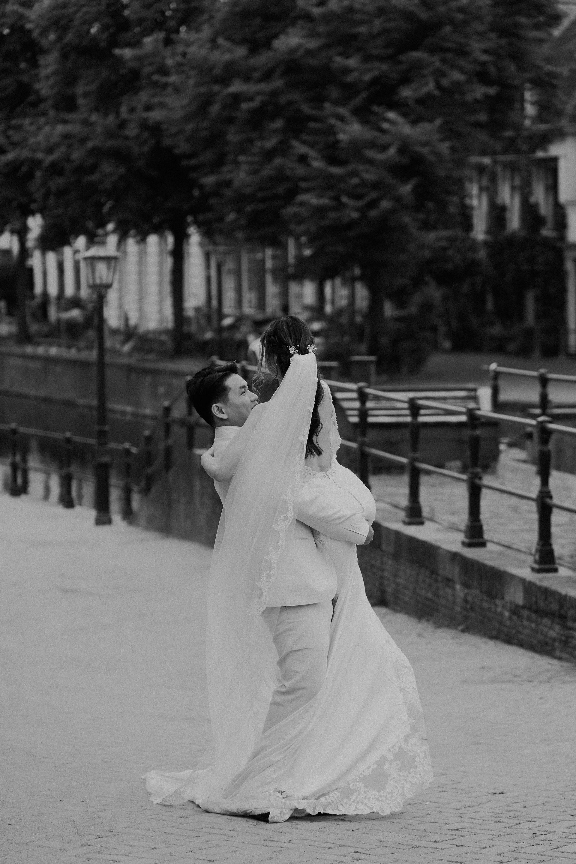 Bruidegom tilt de bruid op tijdens de fotoshoot