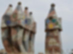 two chimneys covered in mosaic tile. The one at the left has six pots, the one at the right is a single.