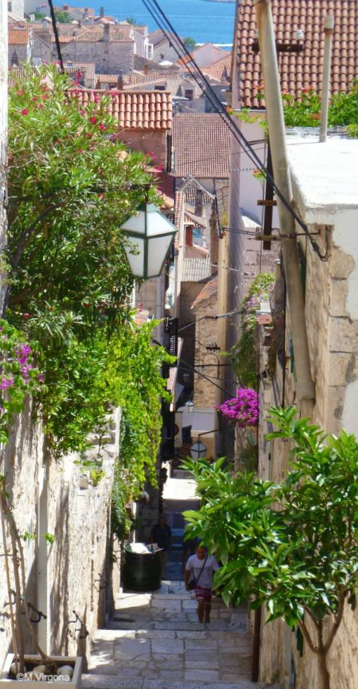 Looking down a narrow street staircase with stone buildings on either side.
