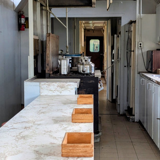 The Kitchen Carriage with a long marble prep counter with a galley kitchen in the background