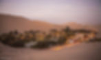 Looking down on the town surrounding a lagoon at twilight with the lights of the town on