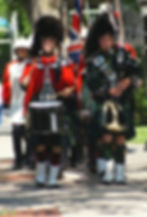 A small parade of uniformed actors, wearing Scottish and British uniforms