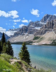 A long blue lake with tall mountains and glaciers in the background