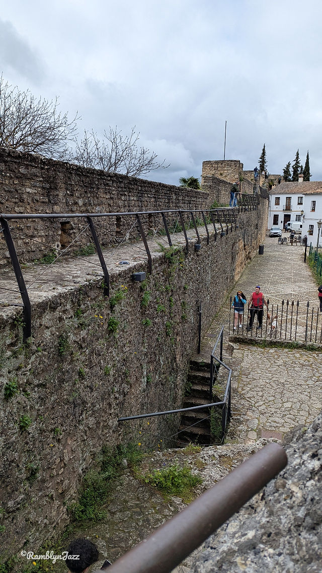 Tall stone walls with a narrow walkway at the top