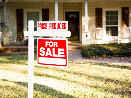 For sale sign with a reduced price outside a home in Bend, Oregon.