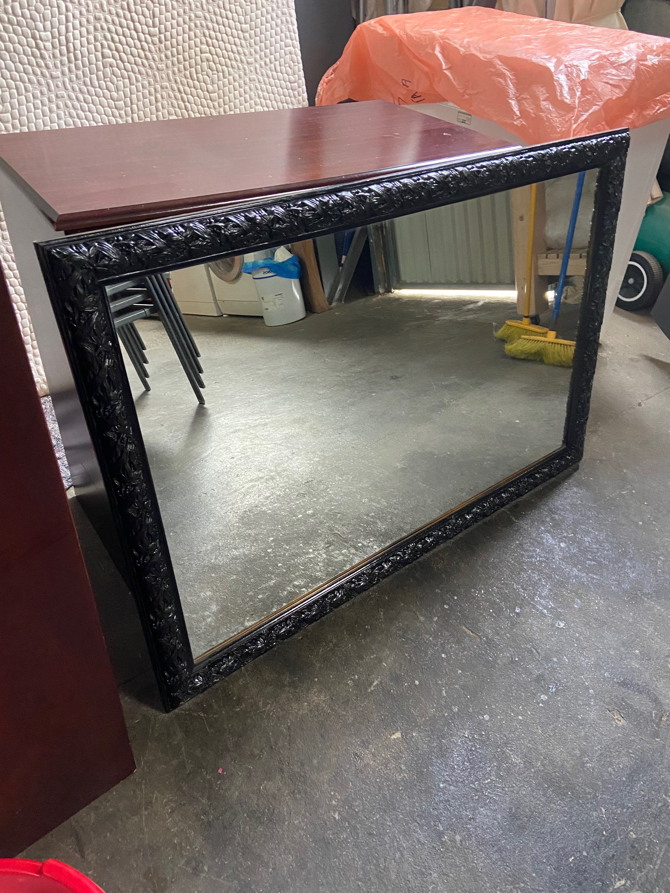 Large black painted ornate framed mirror 