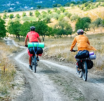 two-cyclists-helmets-with-bicycles-full-traveler-s-stuff-moving-country-road-through-rare-