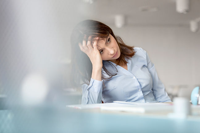 young woman resting head on hand considering calling her employee assistance helpline