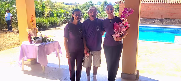 Enedina e Pereira entregam vaso com flor para mestra Jaqueline