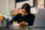 Professional commercial photography of woman writing at desk